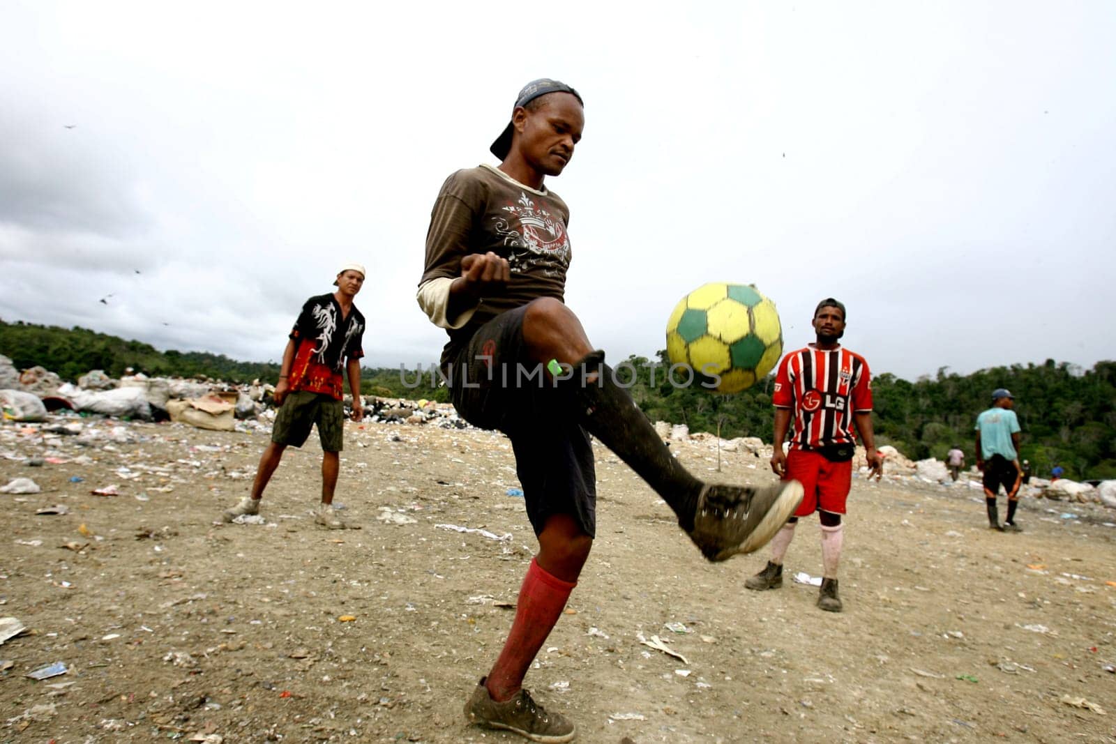 itabuna, bahia / brazil - september 22, 2011: waste pickers are seen playing football at the landfill in the city of itabuna.