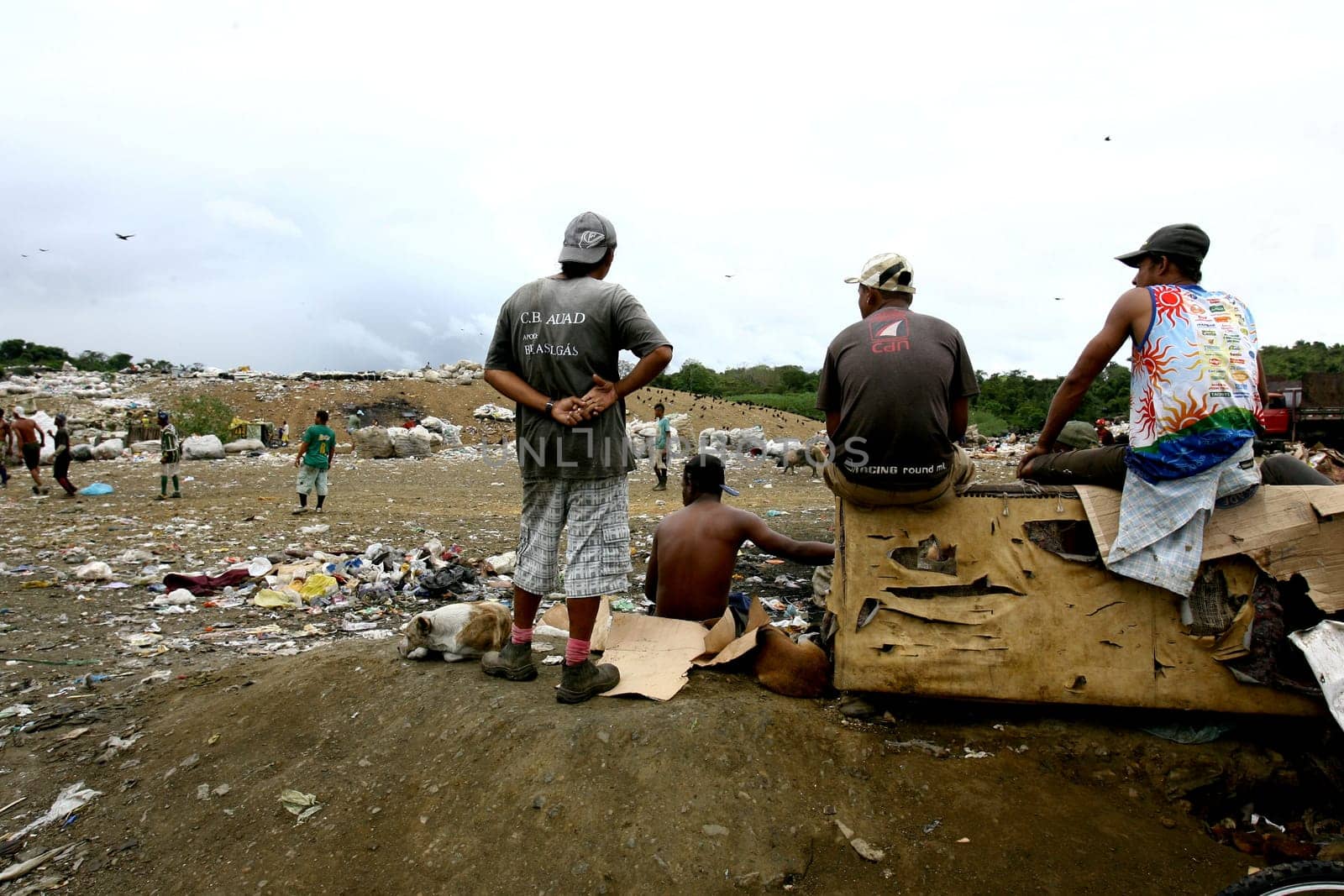 itabuna, bahia / brazil - september 22, 2011: waste pickers watch their colleagues playing football at the sanitary landfill in the city of Itabuna.