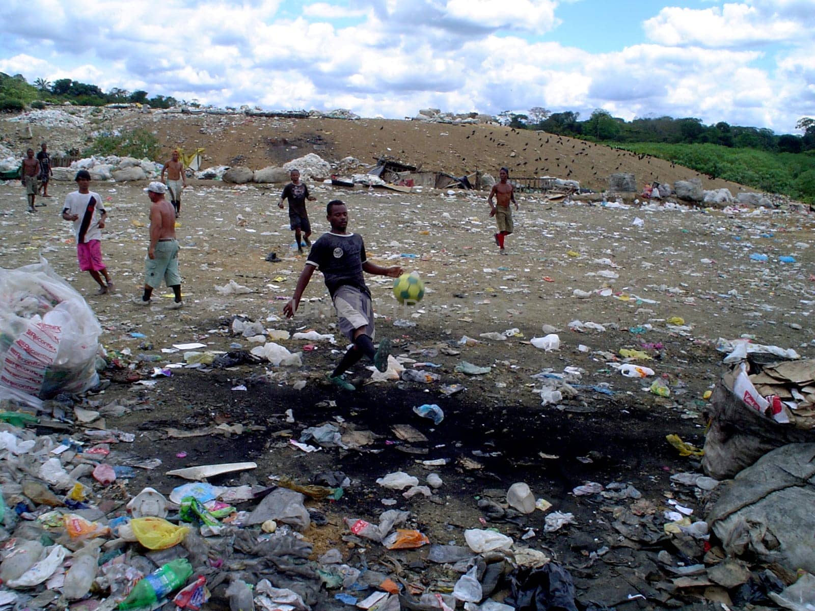 itabuna, bahia / brazil - september 22, 2011: waste pickers are seen playing football at the landfill in the city of itabuna.