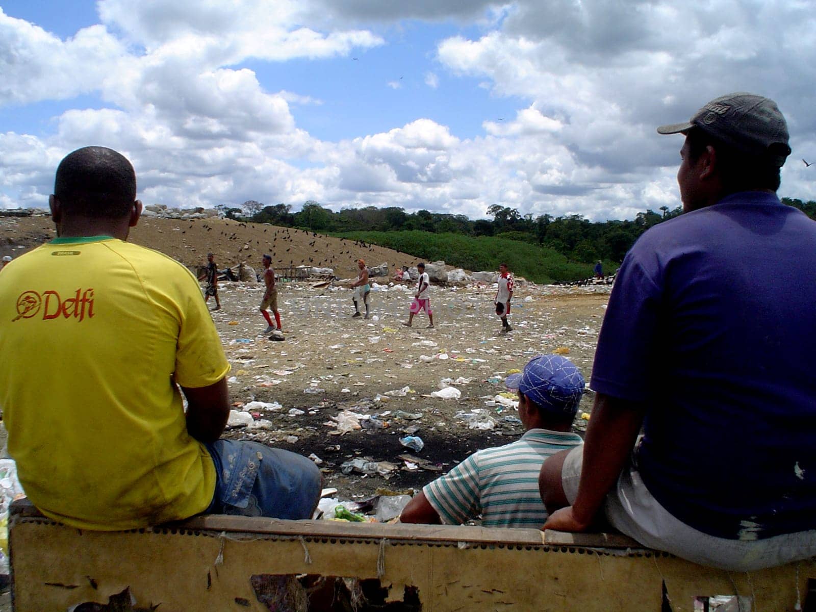 itabuna, bahia / brazil - september 22, 2011: waste pickers watch their colleagues playing football at the sanitary landfill in the city of Itabuna.