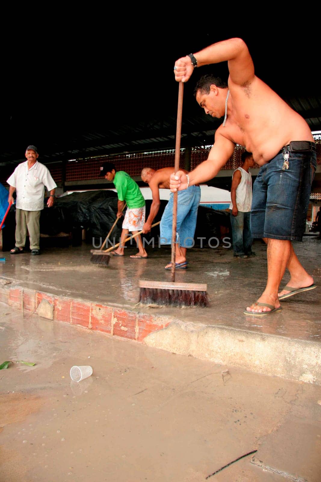 eunapolis, bahia / brazil - june 3, 2009: traders at a street market are seen removing rainwater that fell in the city of Eunapolis.