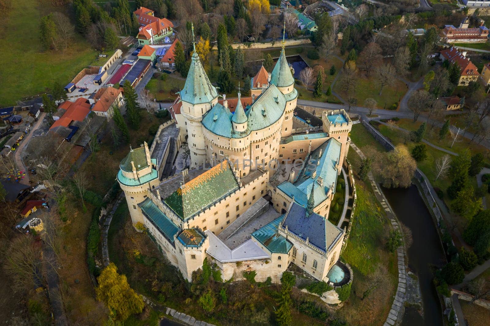 Aerial view of famous castle in Bojnice, Slovakia, from aerial view with road approach and small part of surrounding town. Medieval heritage site and popular tourist destination from top.