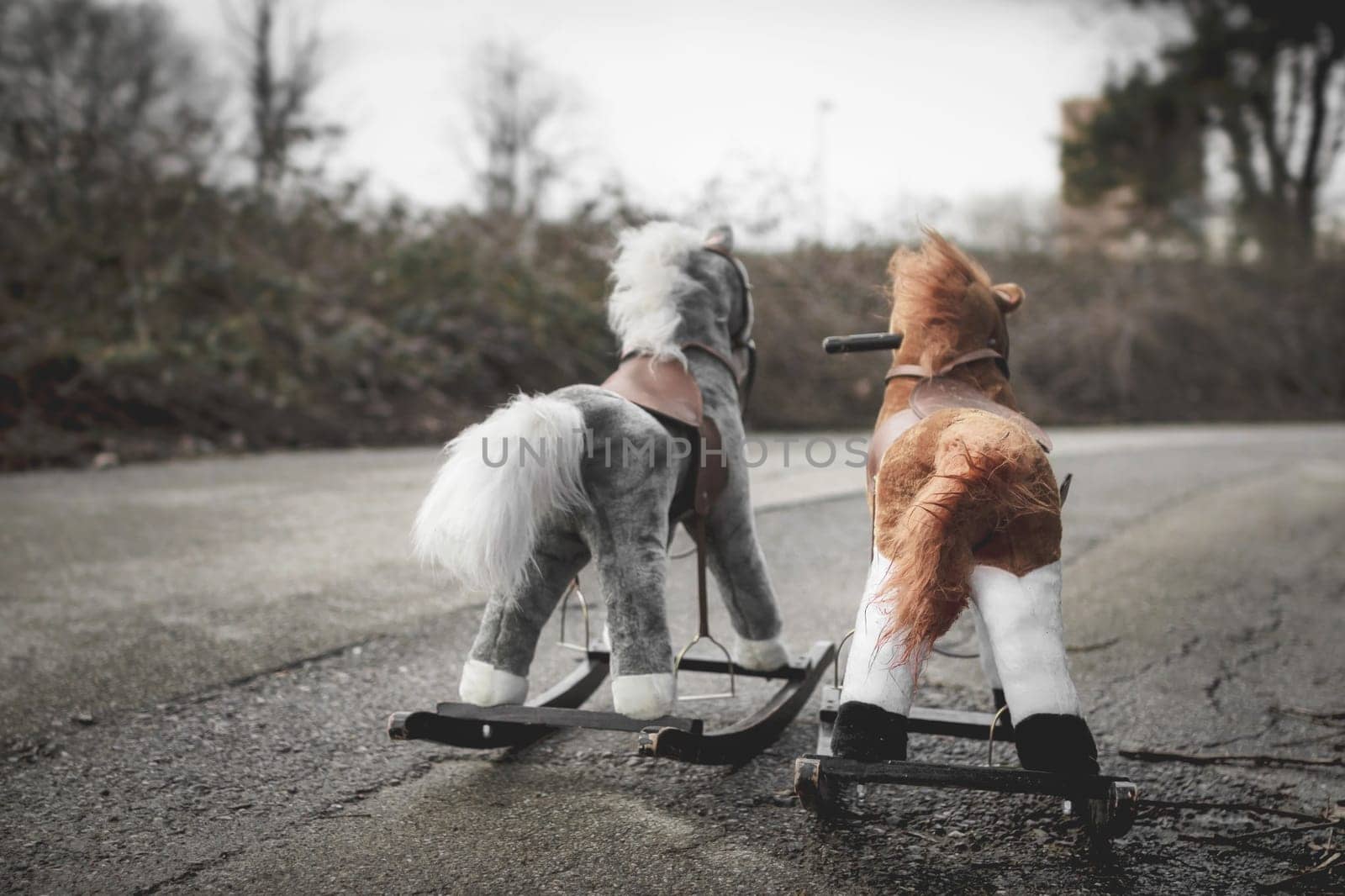 Abandoned rocking horses on the road. Concept of abandonment, loneliness, the end of childhood.