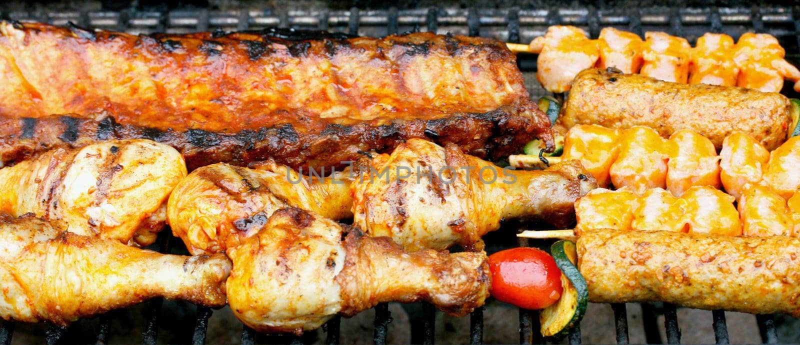 Various pieces of grilled meat on a grill grate