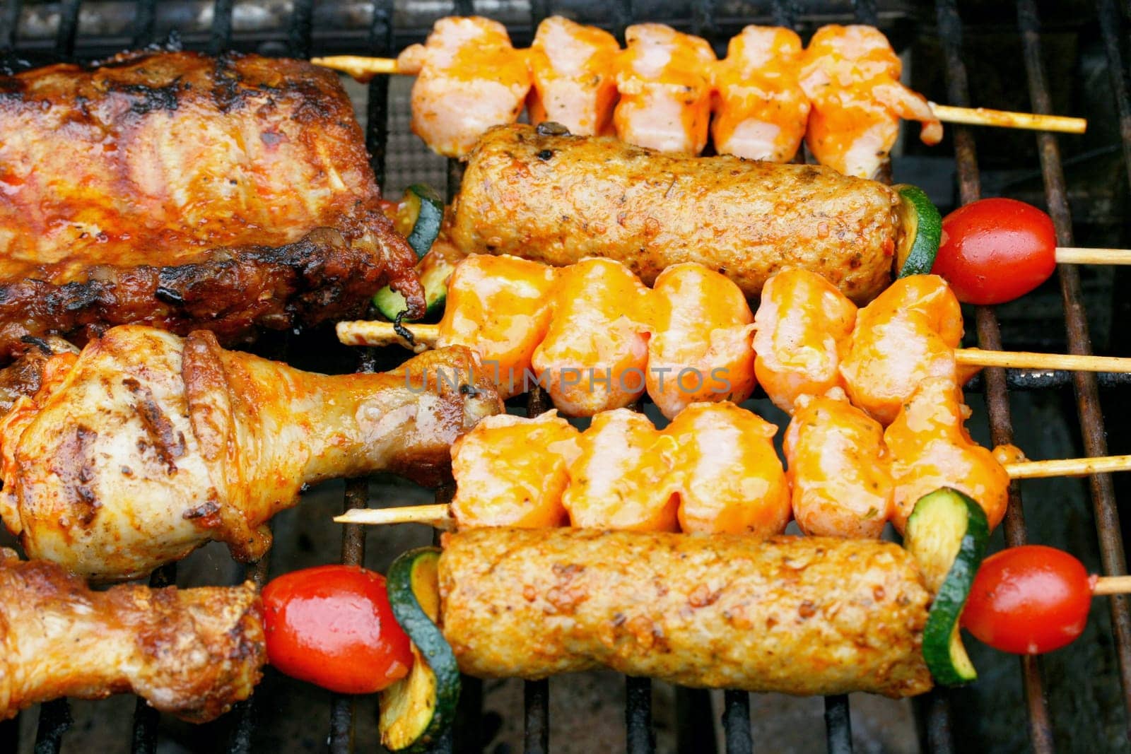 Various pieces of grilled meat on a grill grate