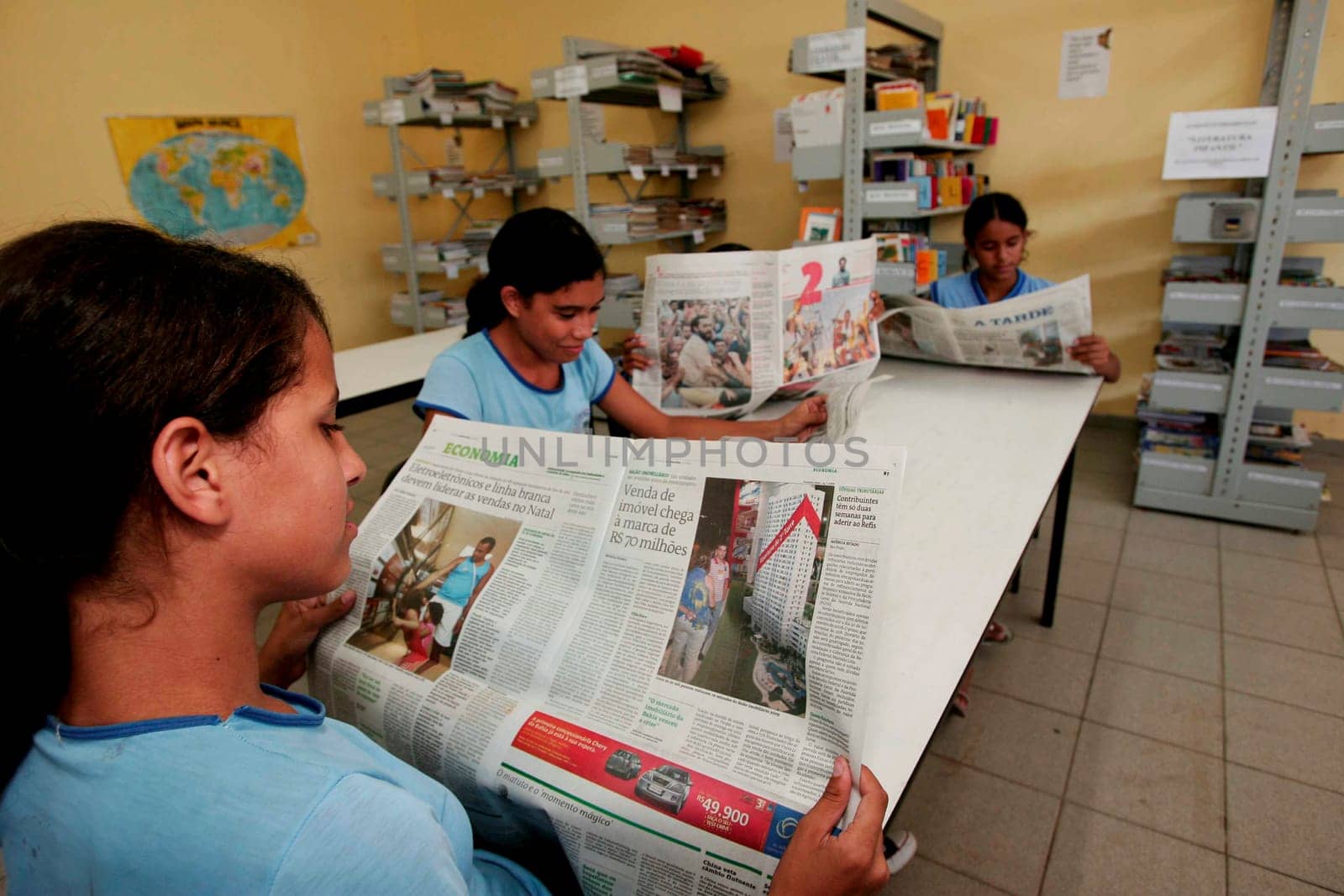 porto seguro, bahia / brazil - november 16, 2009: Public school students are seen reading a newspaper in a library in the city of Porto Seguro.