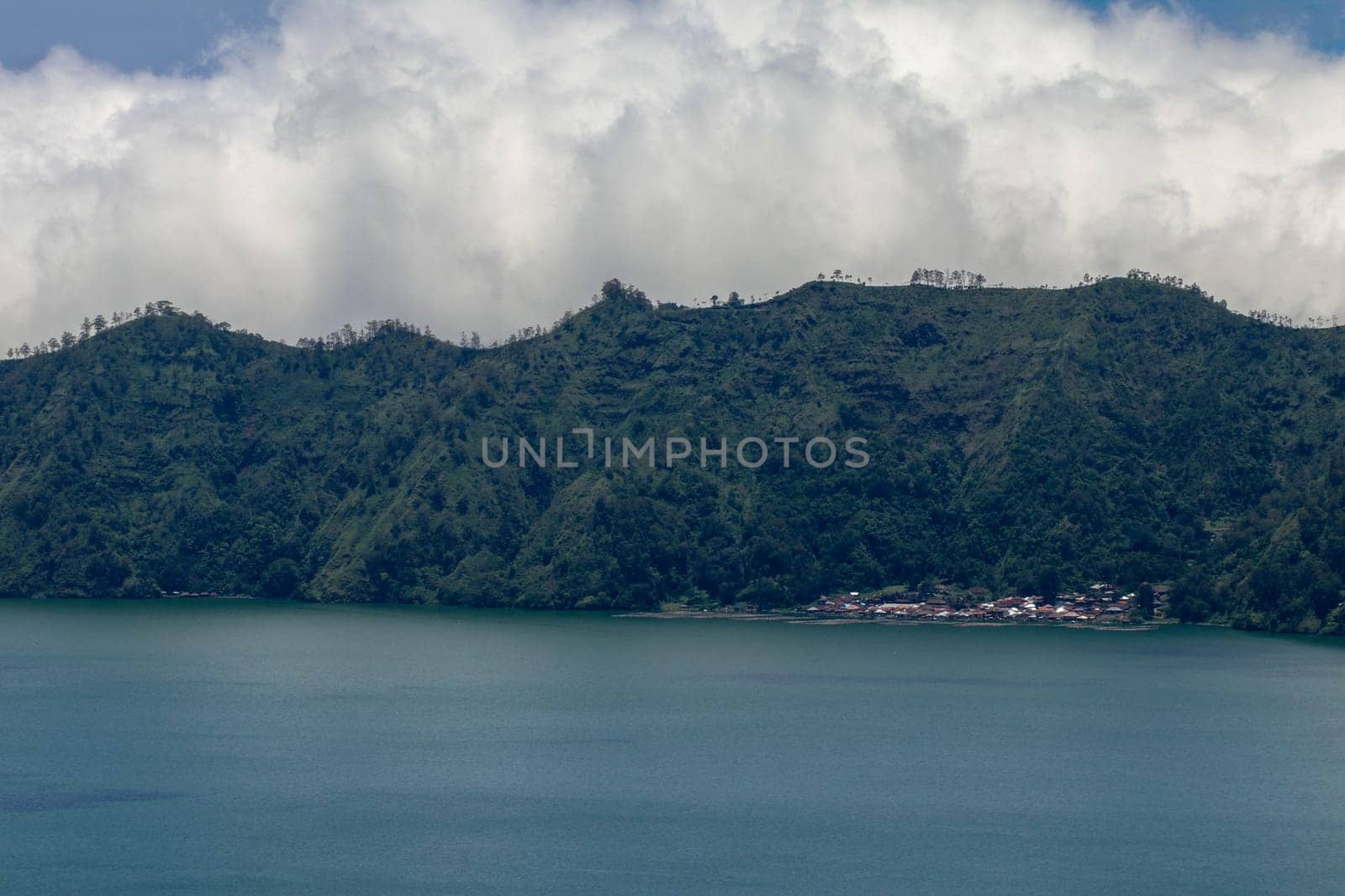 Aerial view over Lake Batur to the traditional village of Trunyan. In this village, the locals bury their deceased above ground. Terunyan is one of the culturally isolated Bali Aga village in Bali.