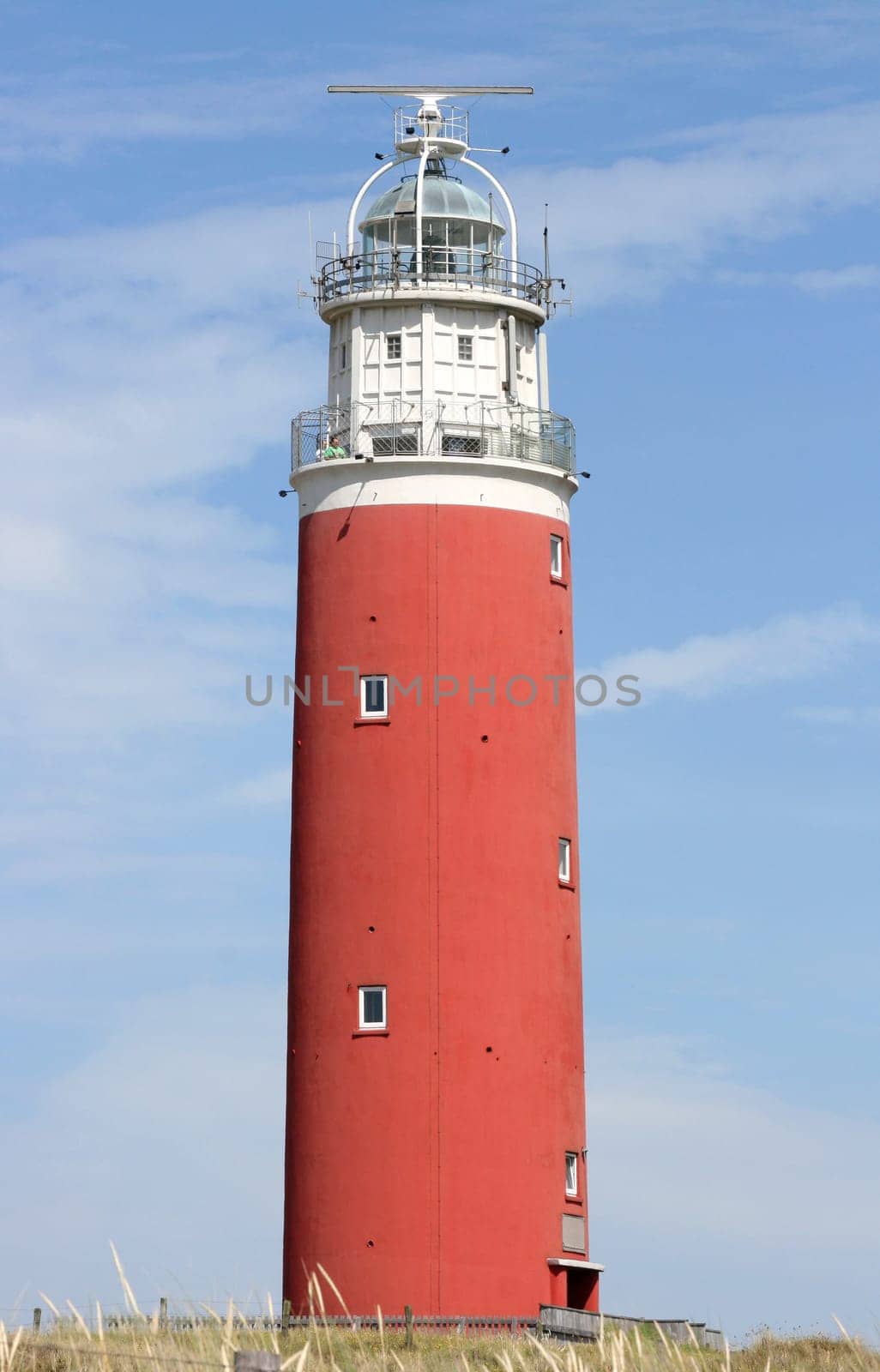 red lighthouse with blue sky in the background.