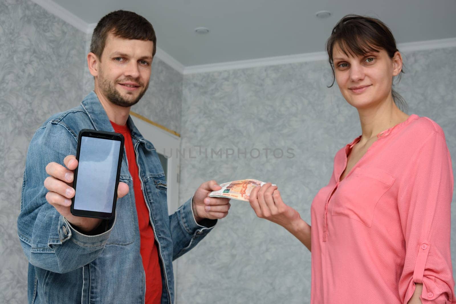 A self-employed man receives money from a girl for repairing a room and shows a phone with the mobile application