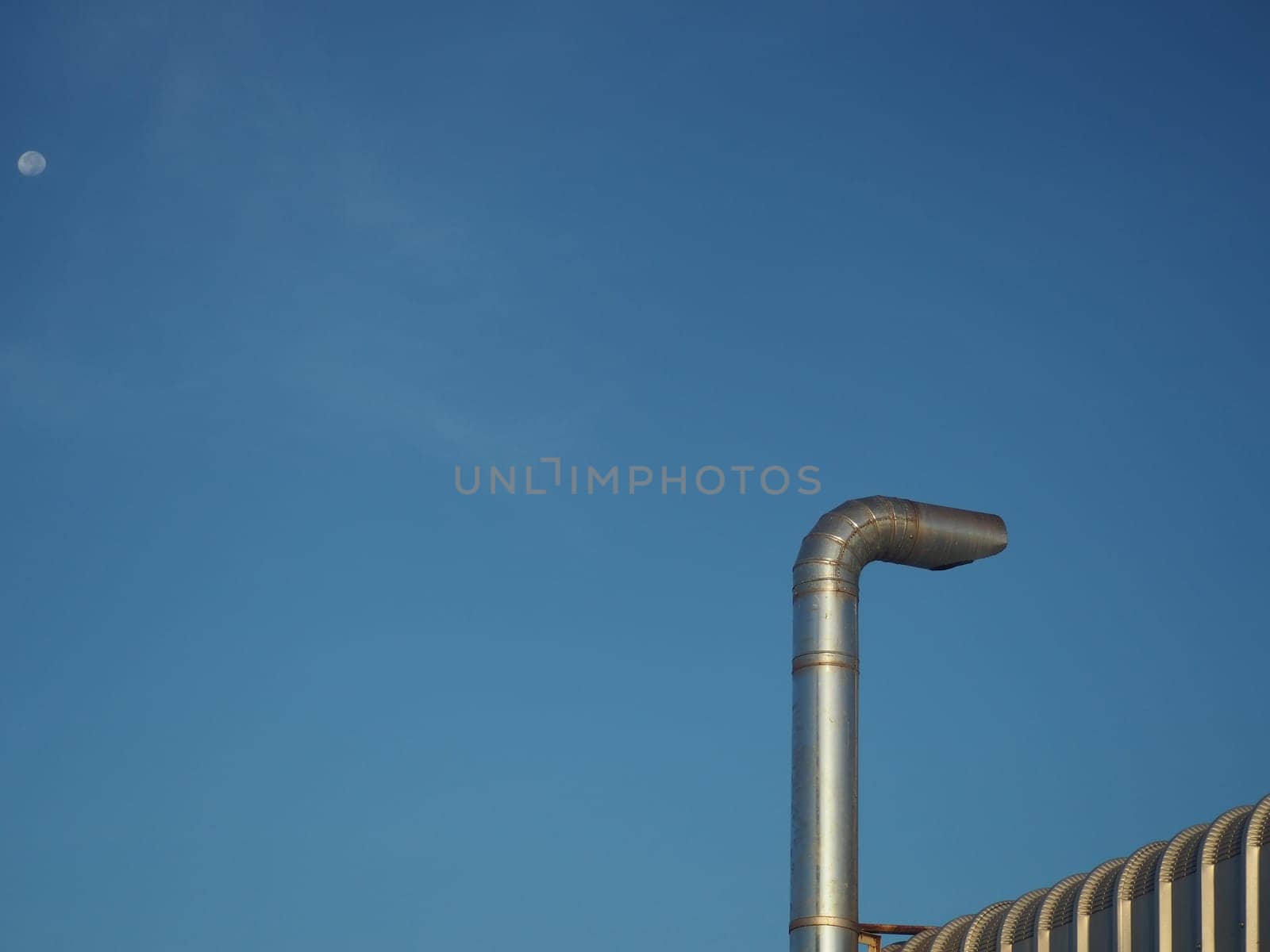 Stainless steel chimney on a blue sky background..Concept of environmental protection.