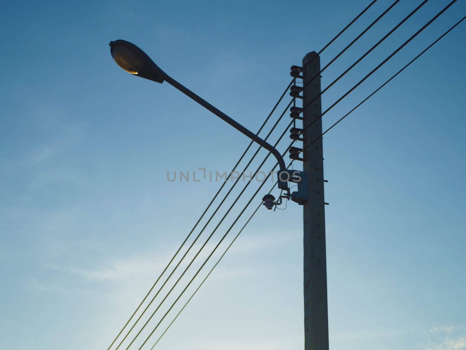 High voltage light poles with street lights attached On a background that is sky With the sun shining in the morning..Energy concept.
