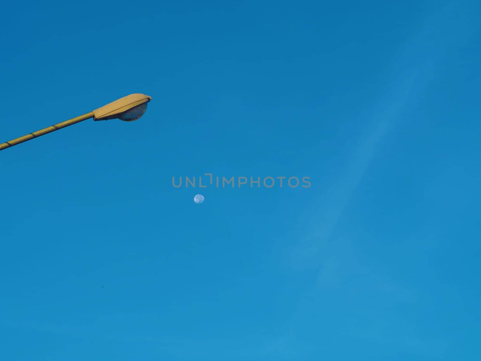 The street light tower on the background is blue sky And there is a small moon in the middle.Energy and nature concepts..Minimal image.