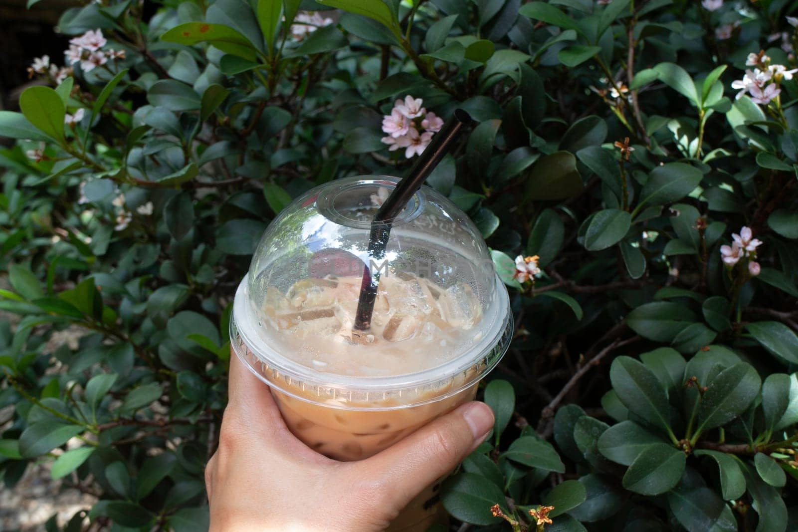 Hand on iced coffee drink, stock photo