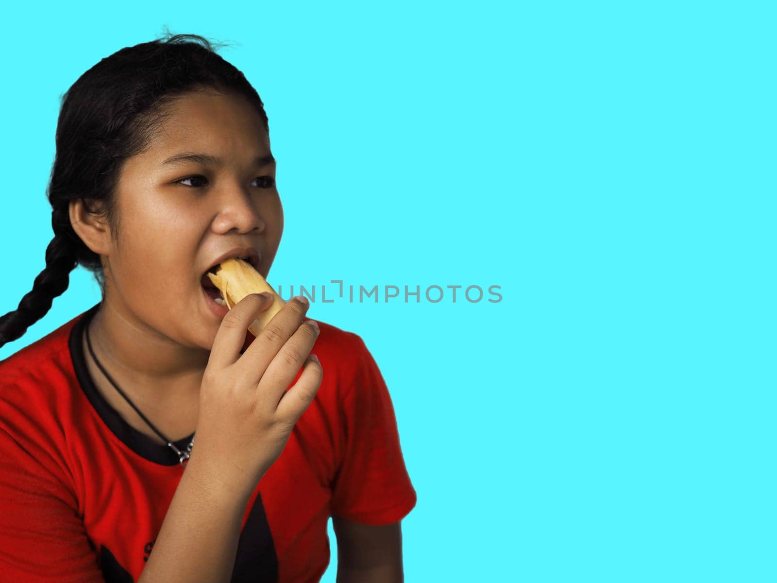 The girl eats hot dog Happily Isolated on a yellow background. Embed clipping path. Junk food concept