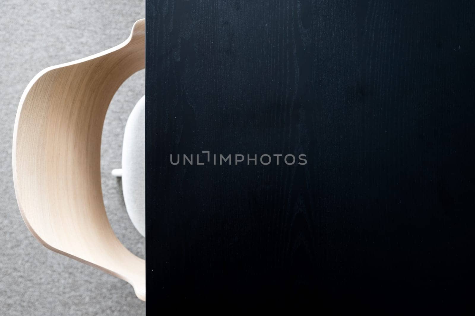 Designers armchair by black office desk. Modern minimalist workplace. Copy space.