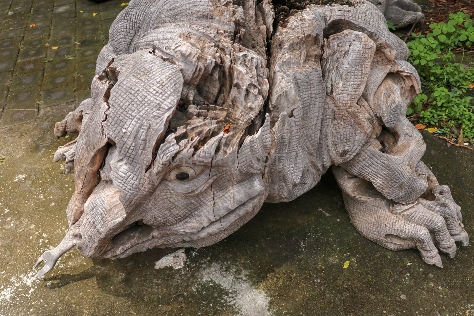 Wooden statue of a lizard. Art and work of Balinese artists. Wooden art. Komodo dragon made of piece of old wood. Big varan art statue from wooden pieces. Ubud, Bali, Indonesia. March 2020.