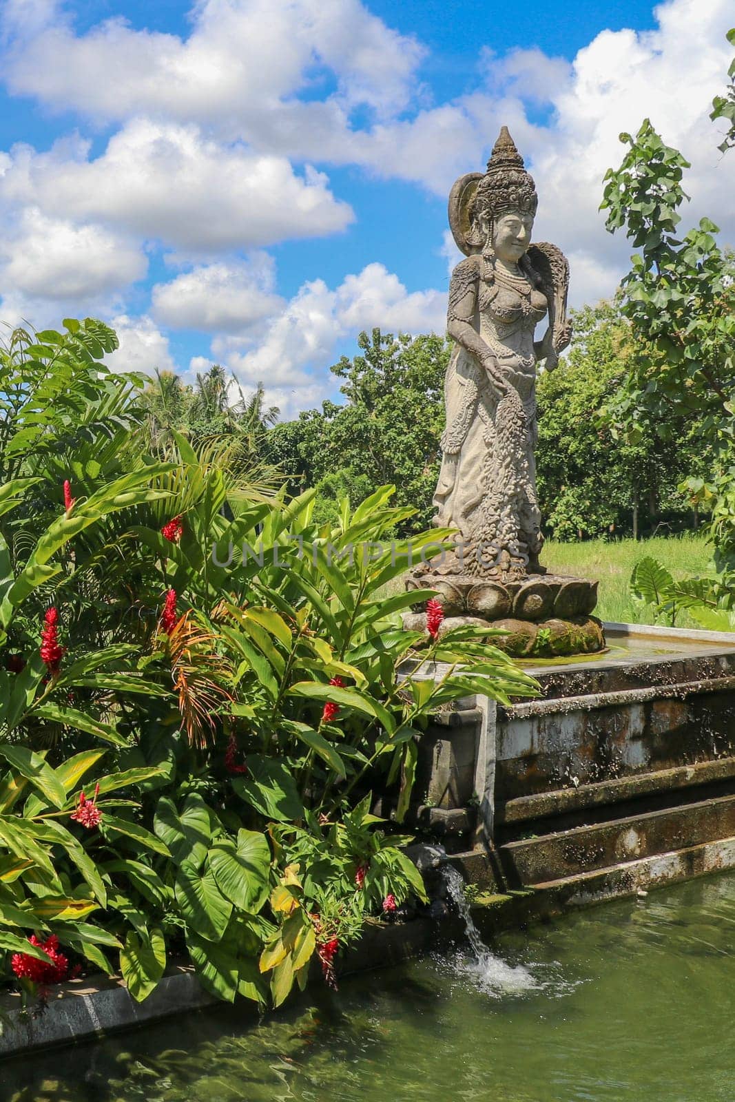 Dewi Sri or Shridevi the rice goddess. Stone figure of one of balinese godness. Water Palace of Tirta Gangga in East Bali, Indonesia. Stone statue from hindu myths.