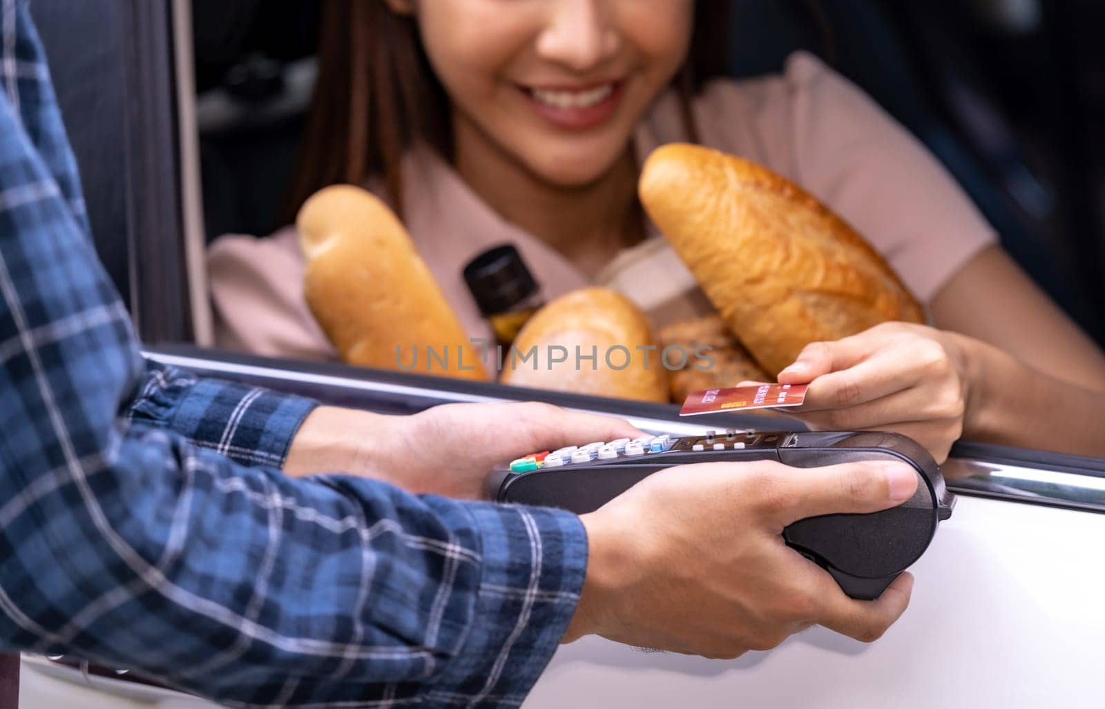 Close up of asian woman make mobile payment contactless technology for online grocery ordering and drive thru service. Drive through and food online is new normal popular after covid-19 pandemic.
