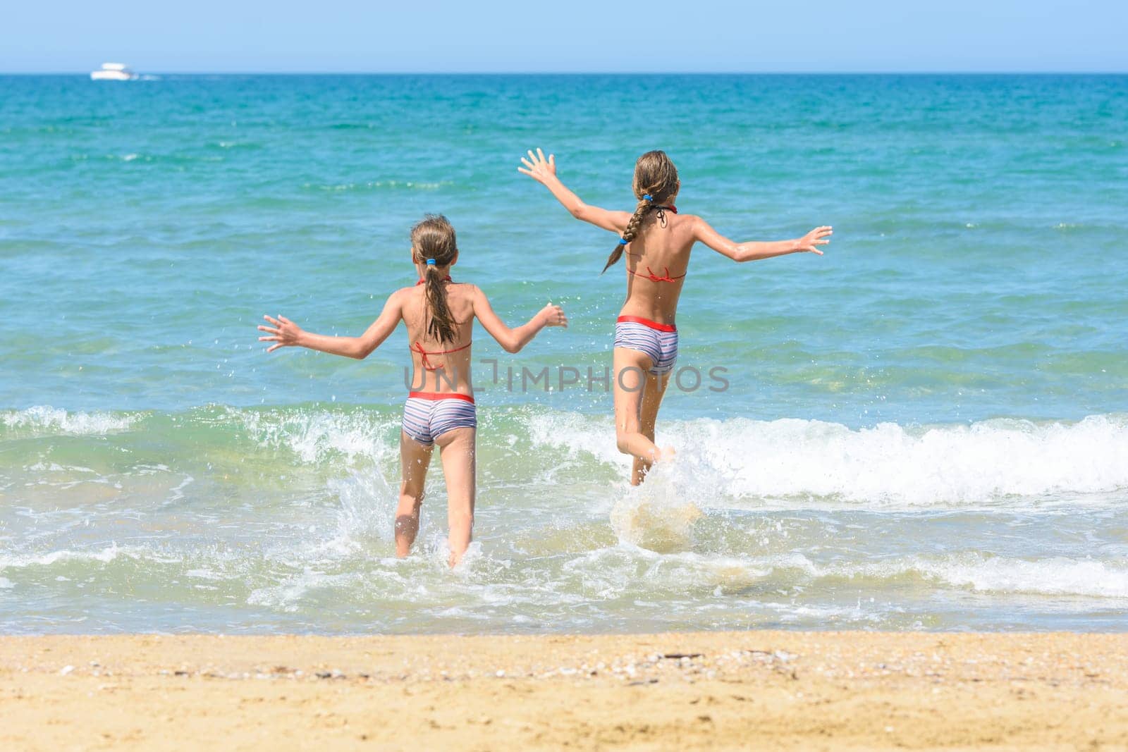 Cheerful children run to swim in the sea