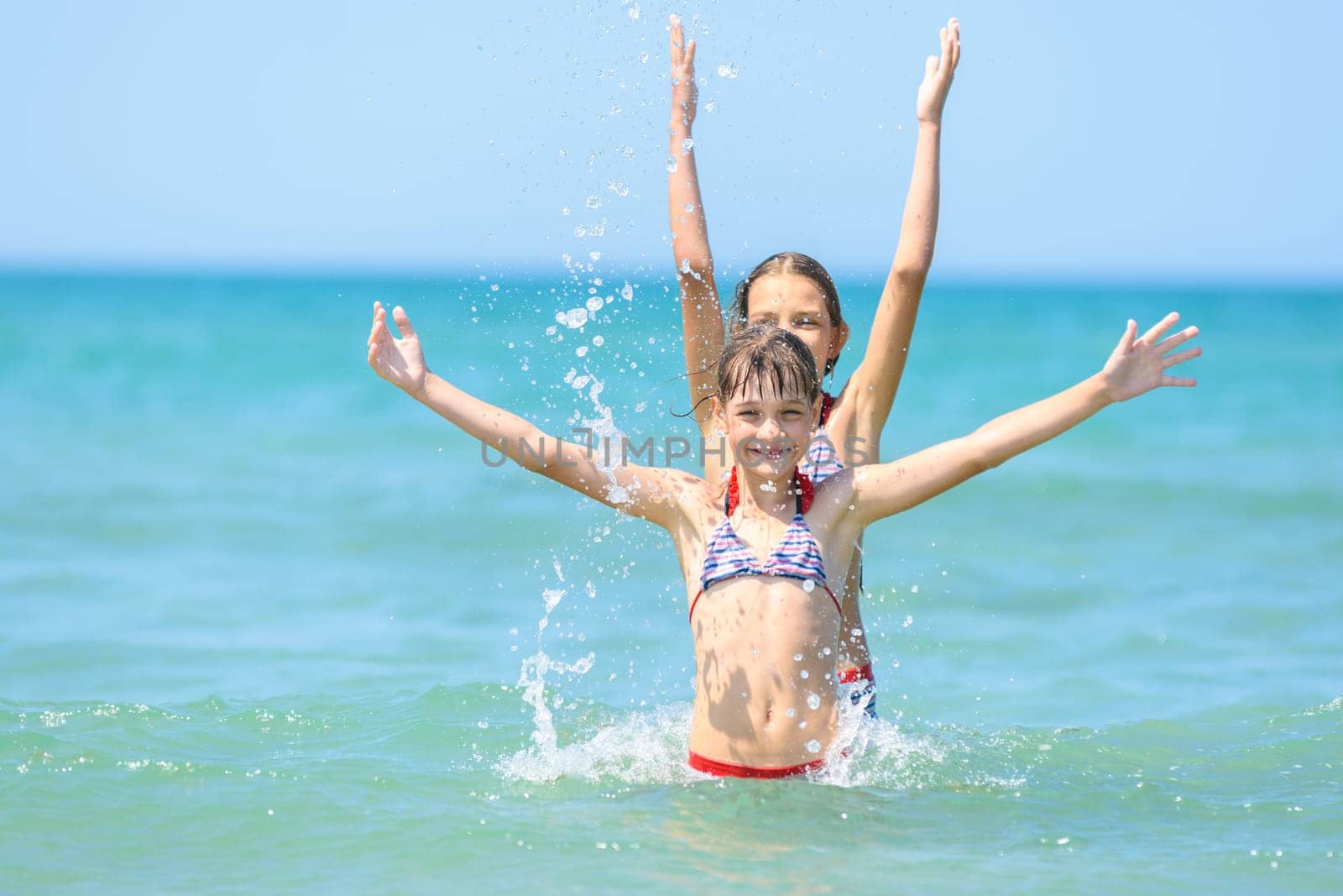 Two girls stood up for each other and joyfully raised their hands up.
