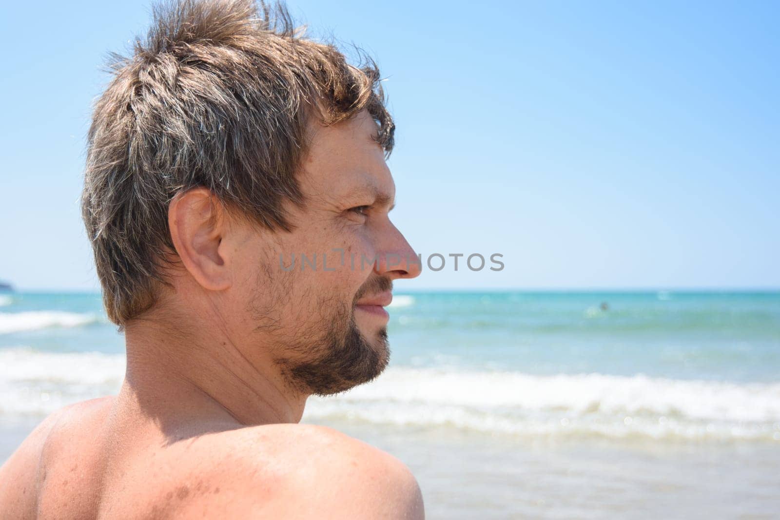 Portrait of an overgrown man of forty years against the background of the sea