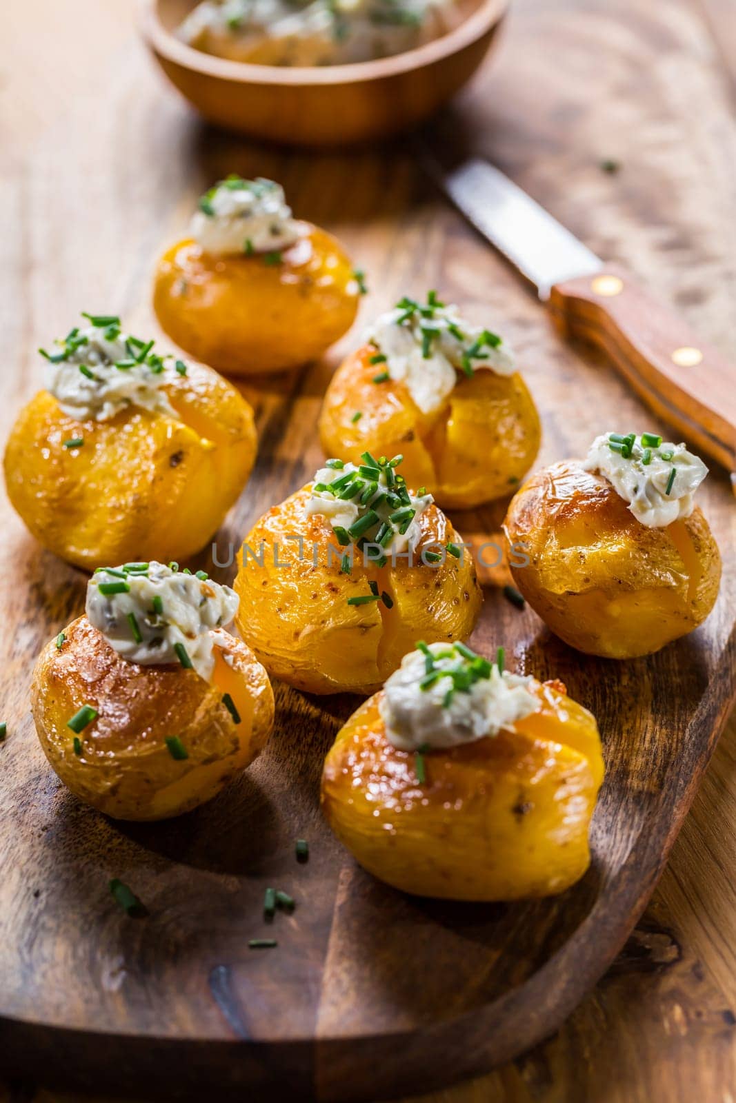 Small oven baked potatoes with sour cream with butter and chives