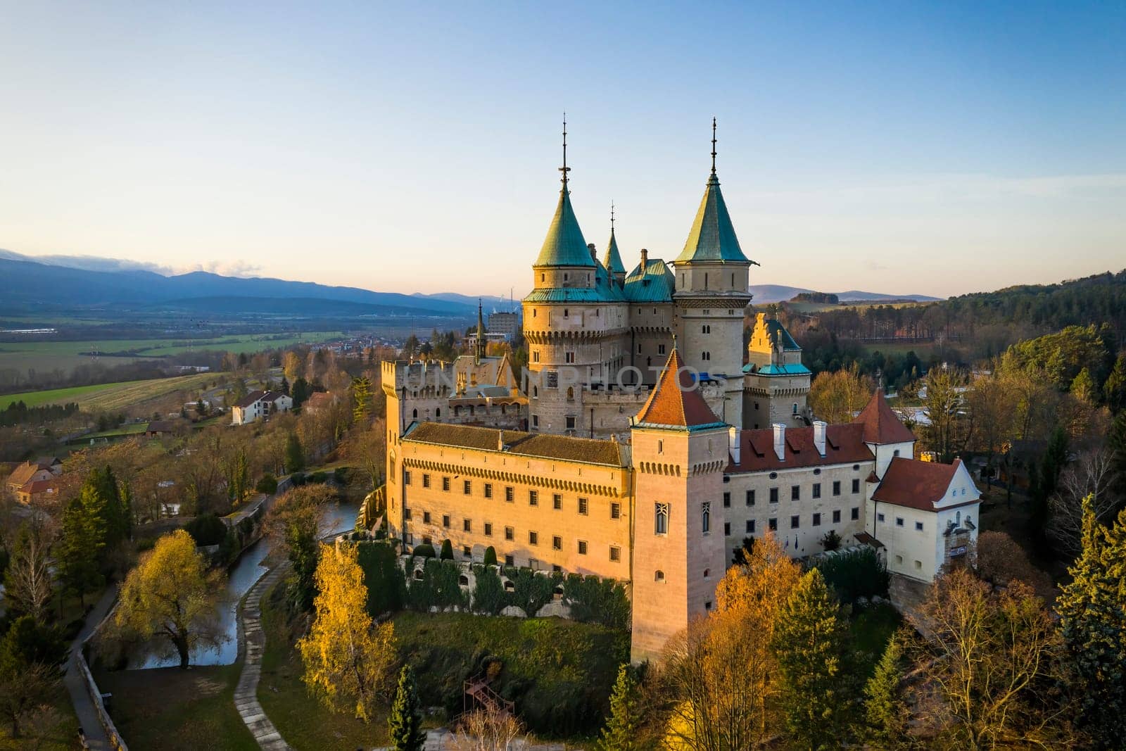 Side view of Bojnice castle with one wall bathed in lovely morning light. Medieval heritage site with towers illuminated by golden light in the morning, Slovakia, Europe.
