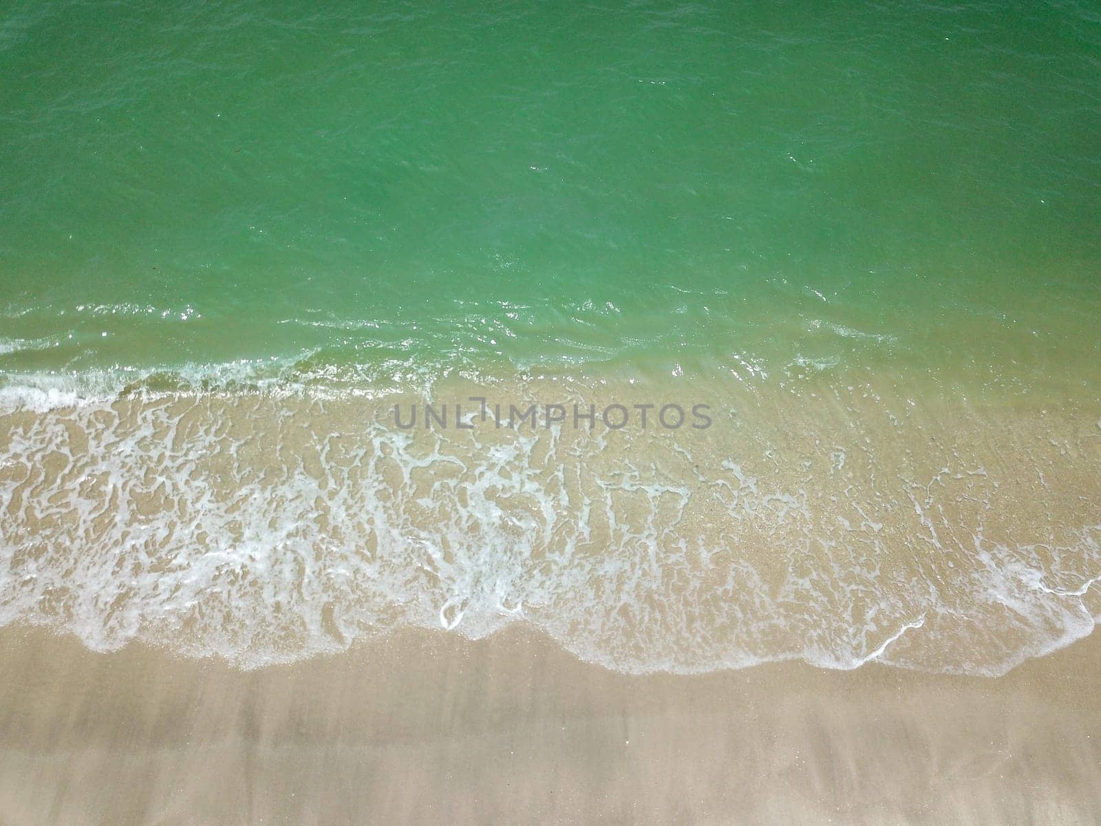 Blue ocean wave on clean sandy beach. Holidays and Travel Concept