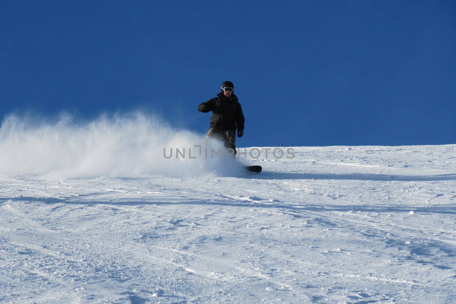 Snowboarder carving a turn on the piste