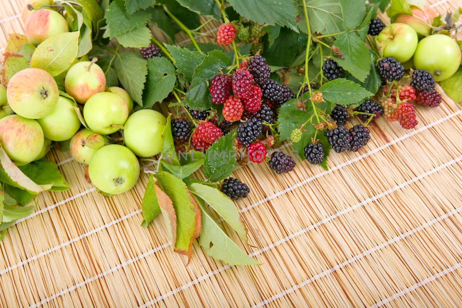 apples and raspberries on a wooden table