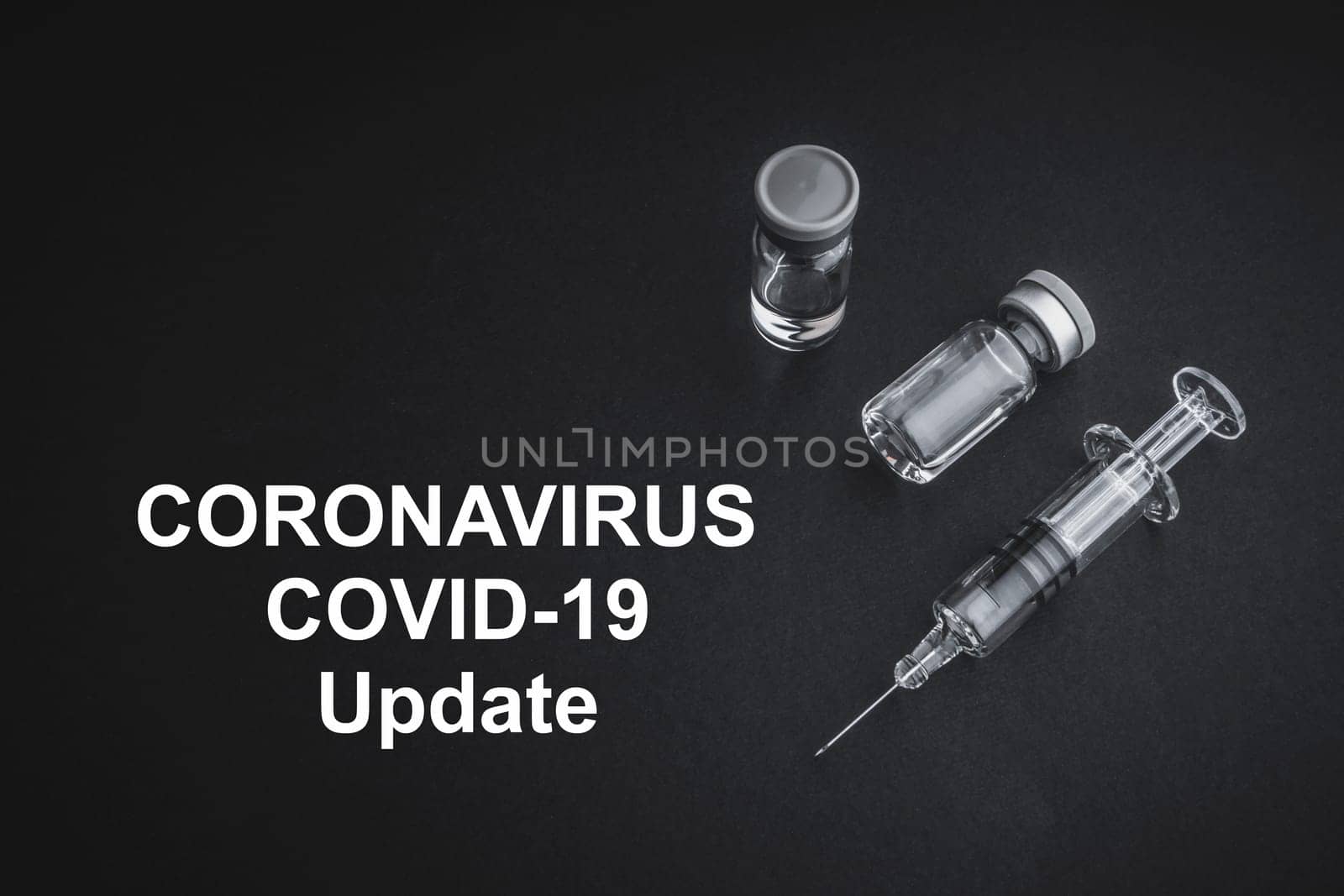 CORONAVIRUS COVID-19 UPDATE text with syringe and vials on black background. Covid-19 and Coronavirus concept