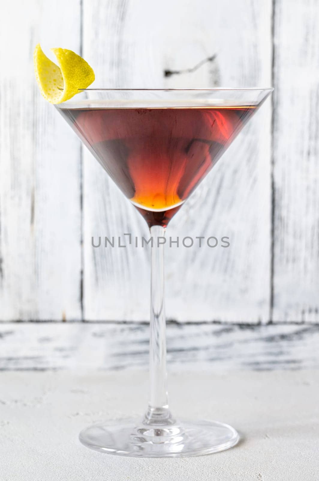 Glass of Martinez cocktail garnished with lemon zest