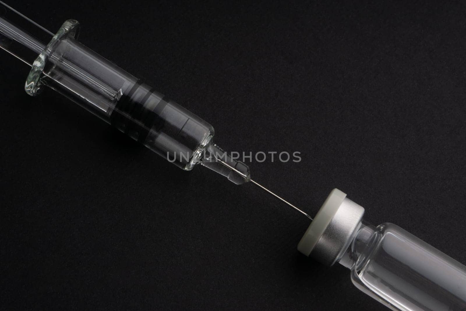 Closeup syringe and vials on black background. Healthcare dan Copy Space concept