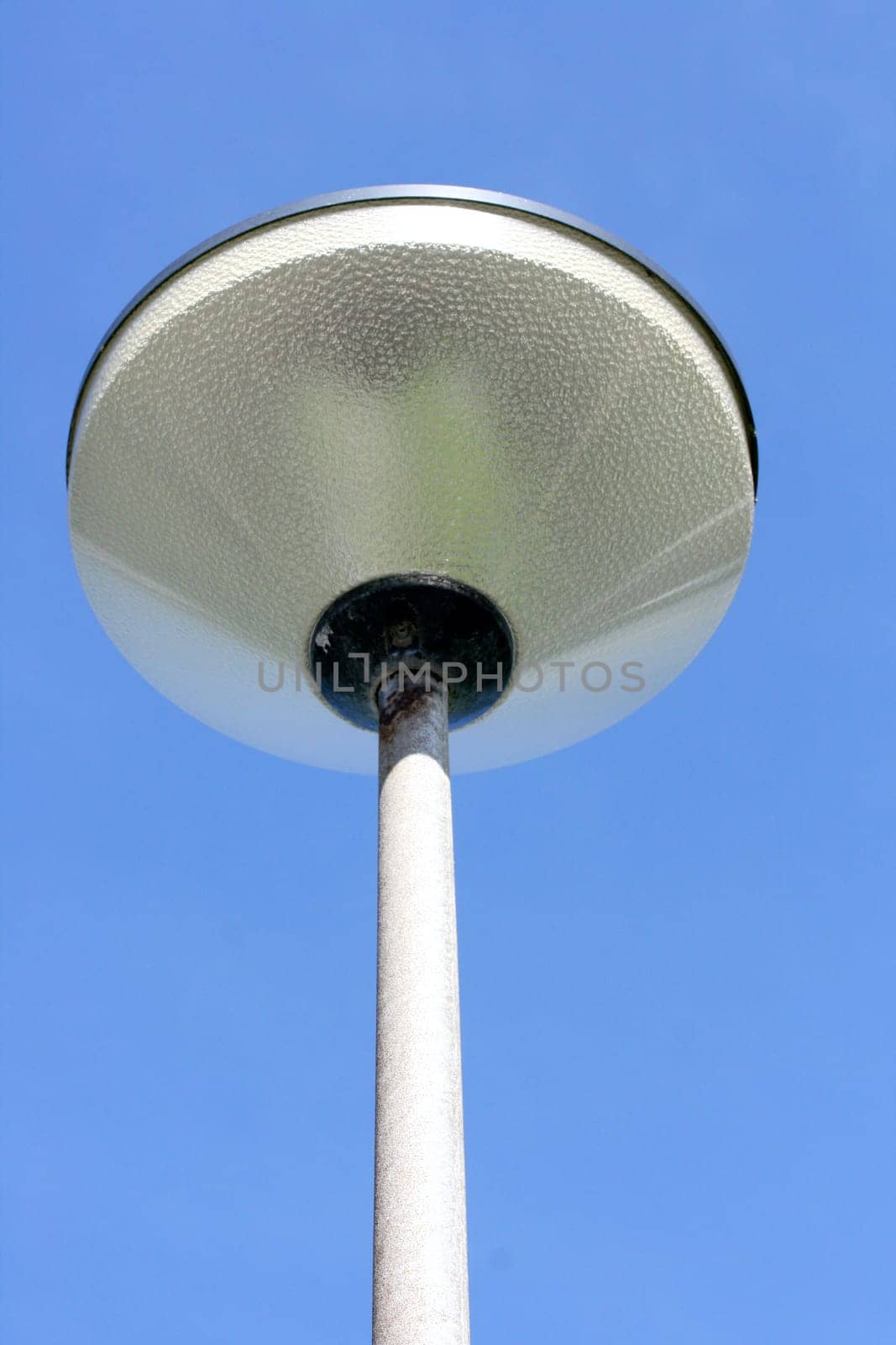 A street lamp, blue sky in the background.