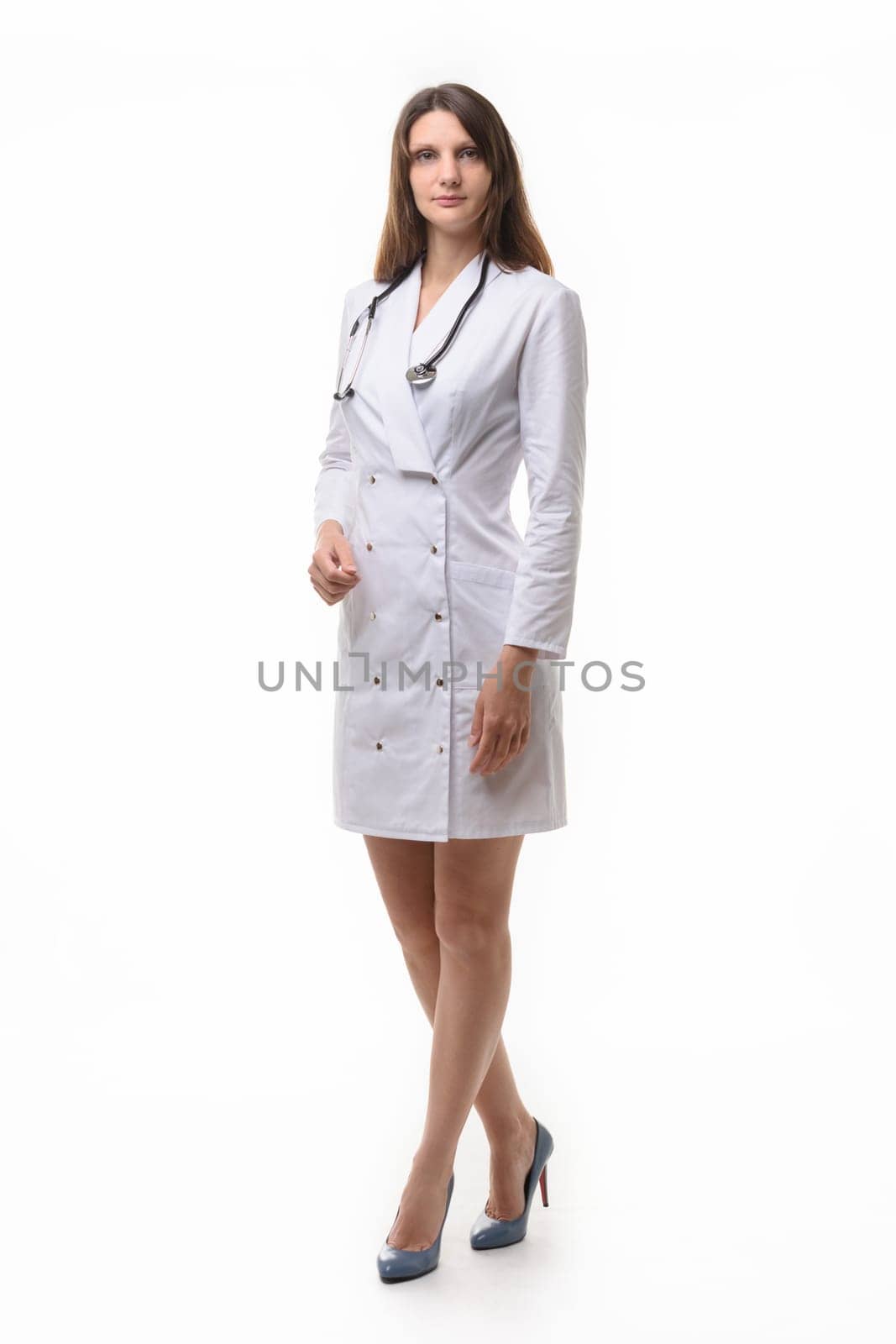 Model in medical clothing with stethoscope poses on a white background