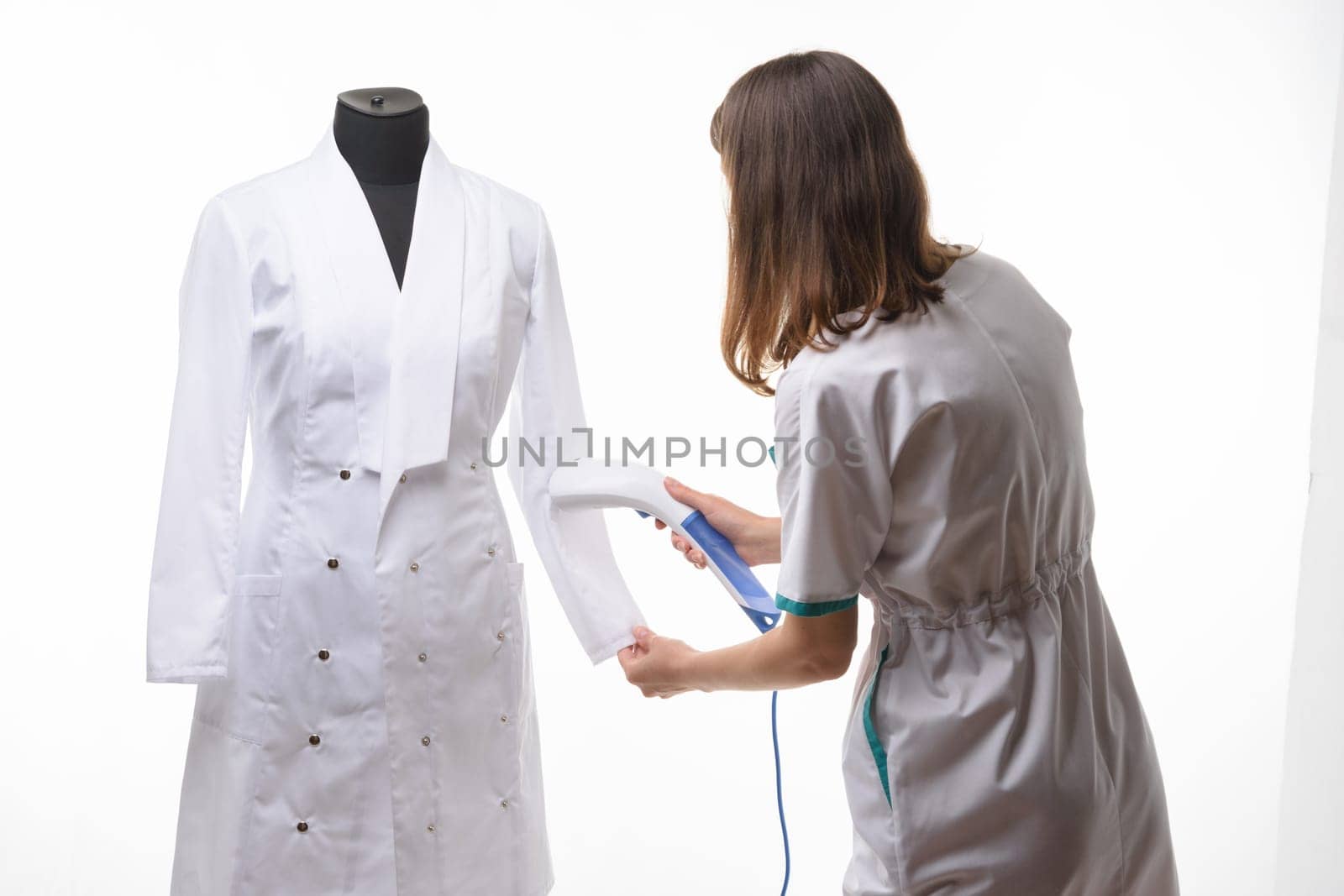 Girl in medical clothes handles steam clothes on manicure