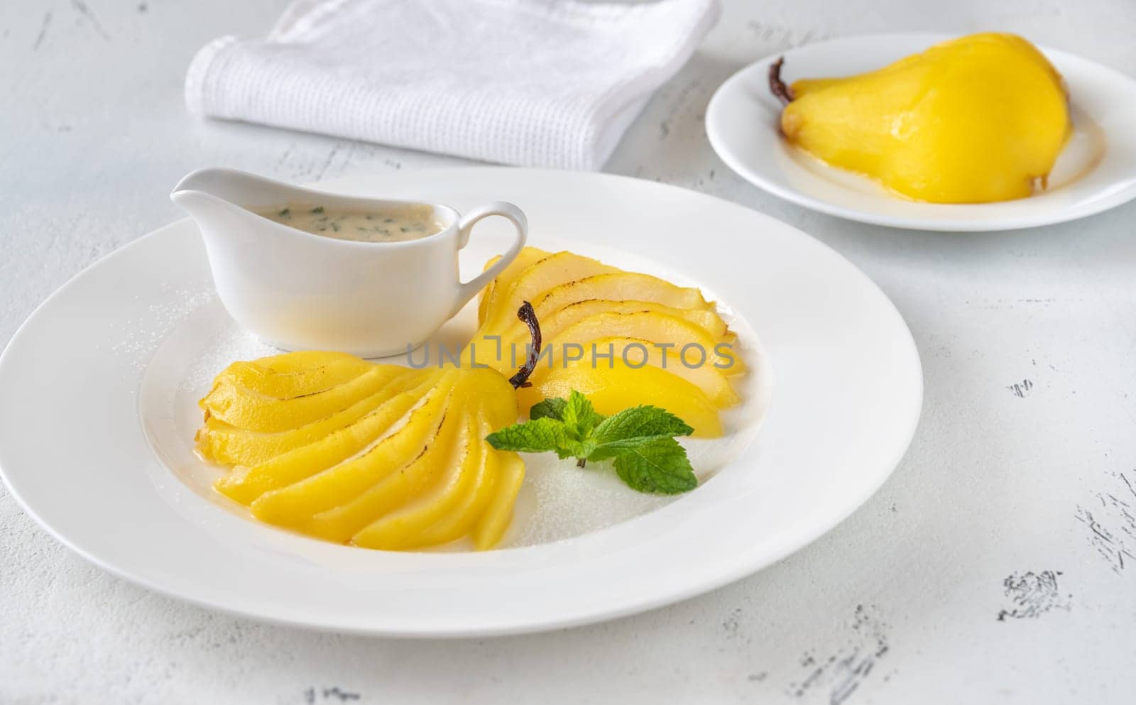 Portion of Saffron Poached  Pears on white plate