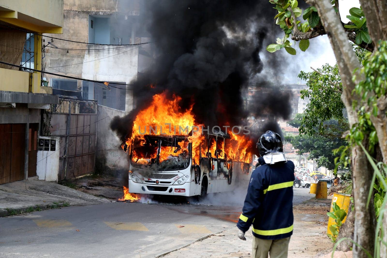 salvador, bahia / brazil - january 23, 2015: a member of the fire brigade extinguishes a fire in a public transport bus in the city of Salvador.