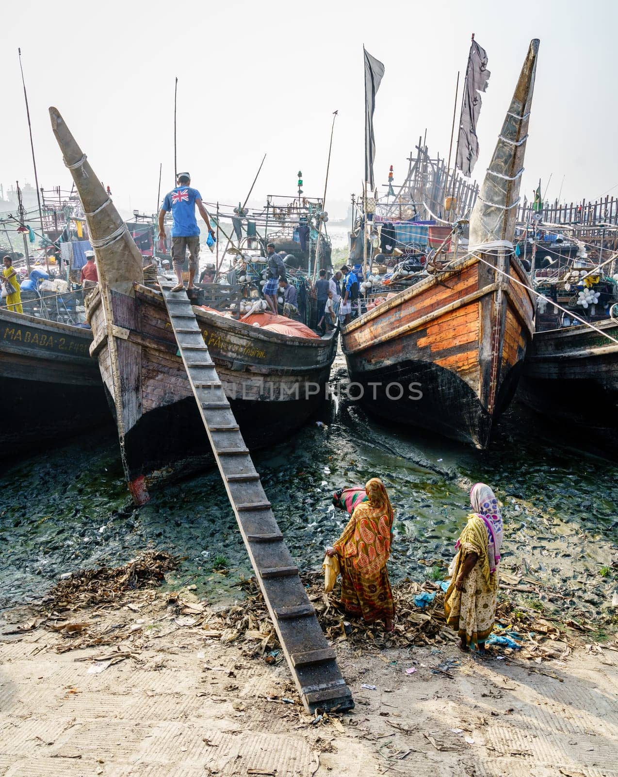 Chittagong, Bangladesh, December 23, 2017: Fishermen are about to unload fresh catch from the boat as local women look on