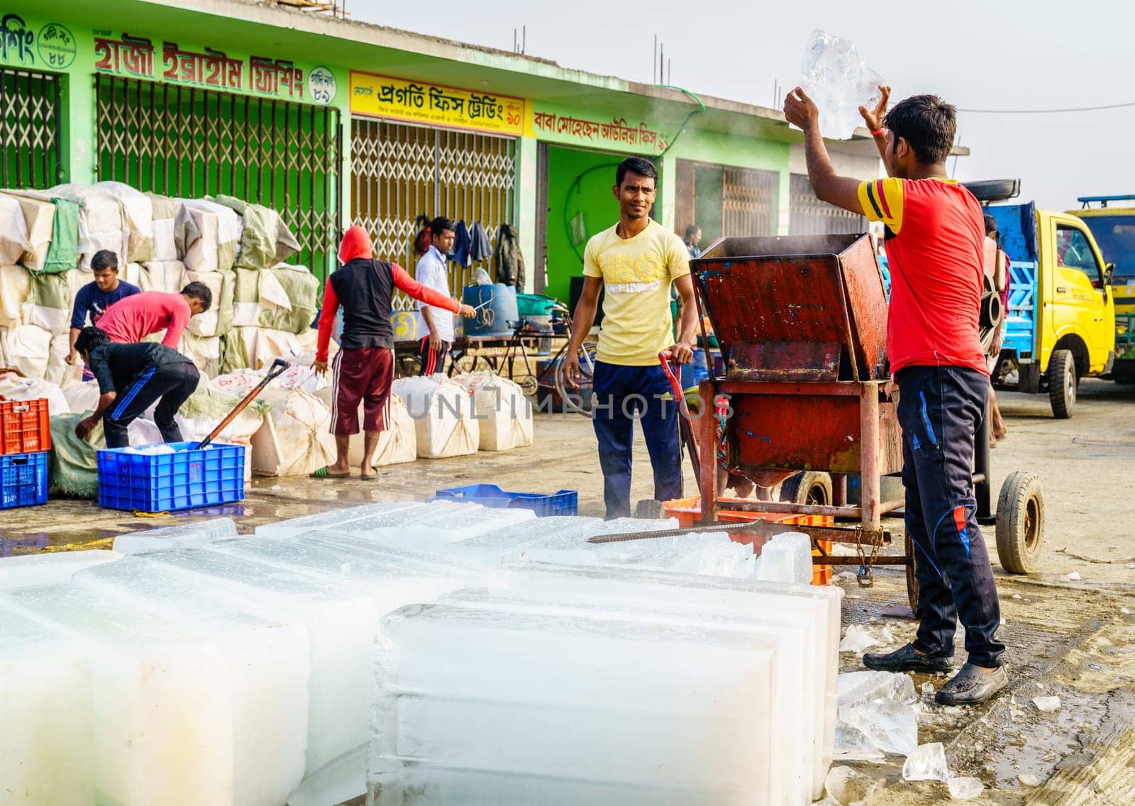 Chittagong, Bangladesh, December 23, 2017: Workers are chopping blocks of ice at the fish market near Karnaphuli River in Chittagong