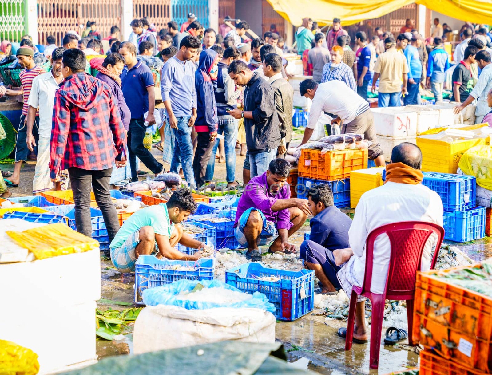 Chittagong, Bangladesh, December 23, 2017: Vendors sorting fish at the crowded market near Karnaphuli River in Chittagong