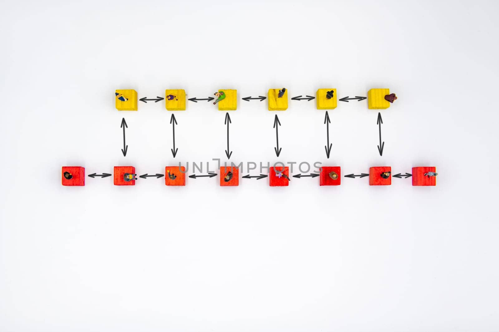 Miniature figurines standing socially distanced on wooden cubes with drawn arrows isolated over white background