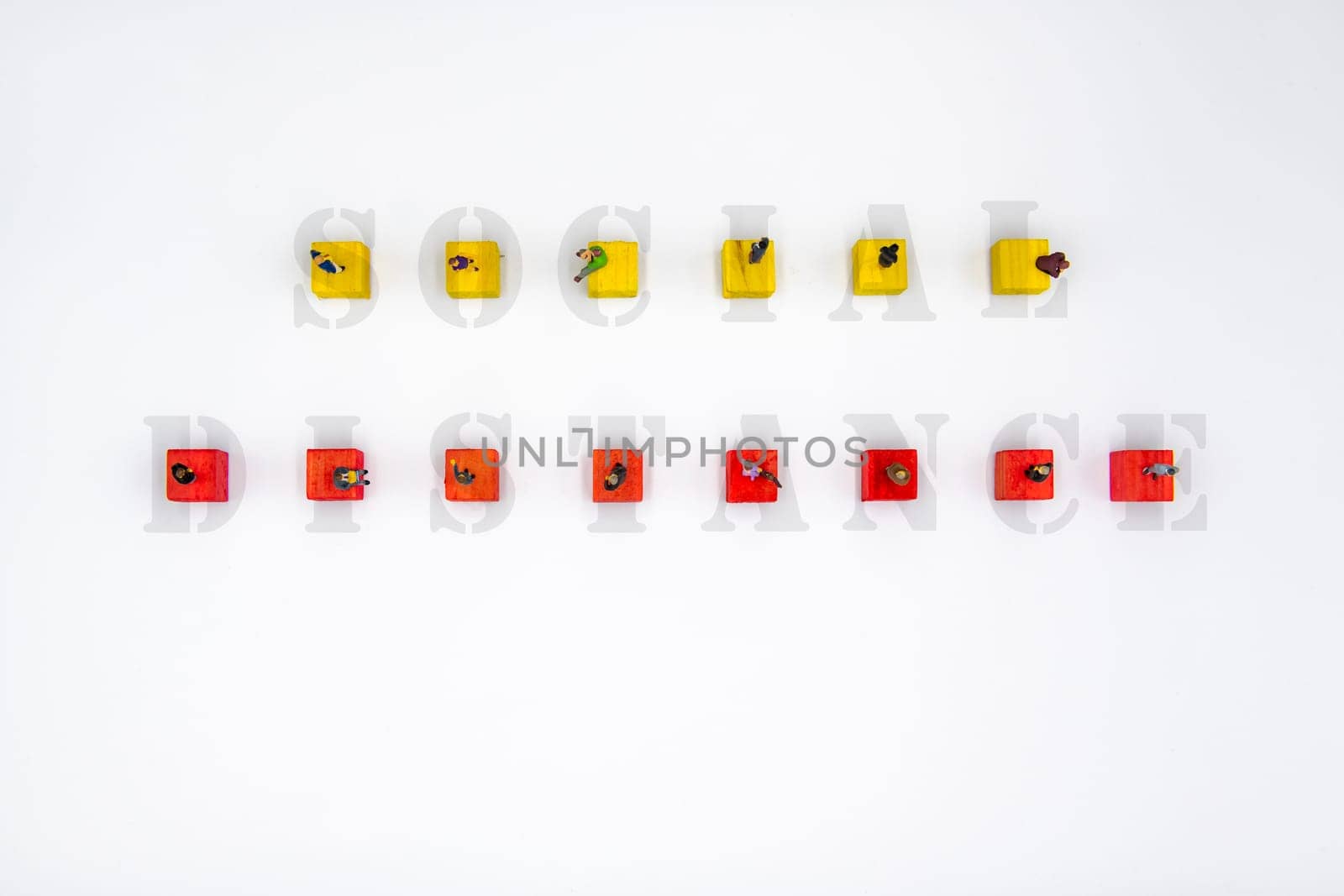 Miniature figurines standing on wooden cubes with message Social Distance isolated over white background
