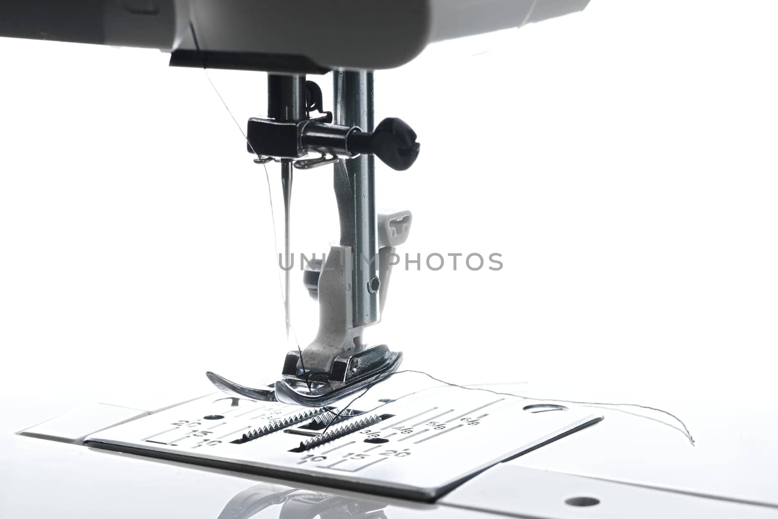 8 - Medium horizontal image of sewing machine working area. Plate foot needle thread and housing above is all visible.