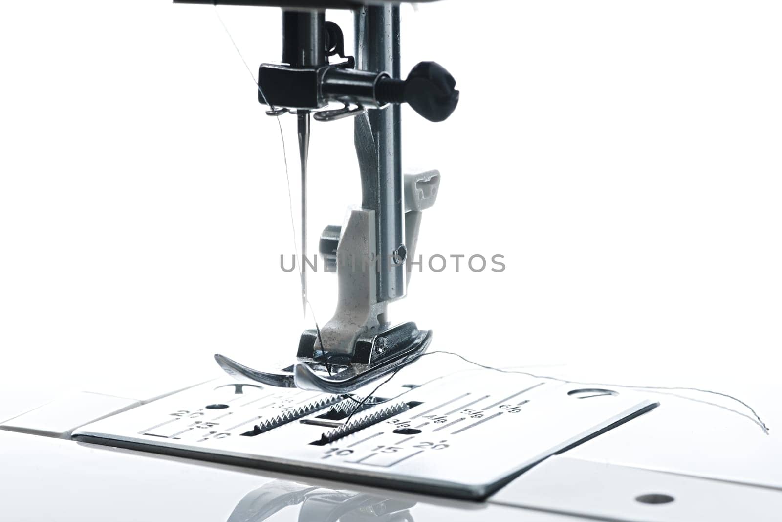 7 - Back lit close up macro image of the needle thread and working area. High contrast and the feed dogs stand out.
