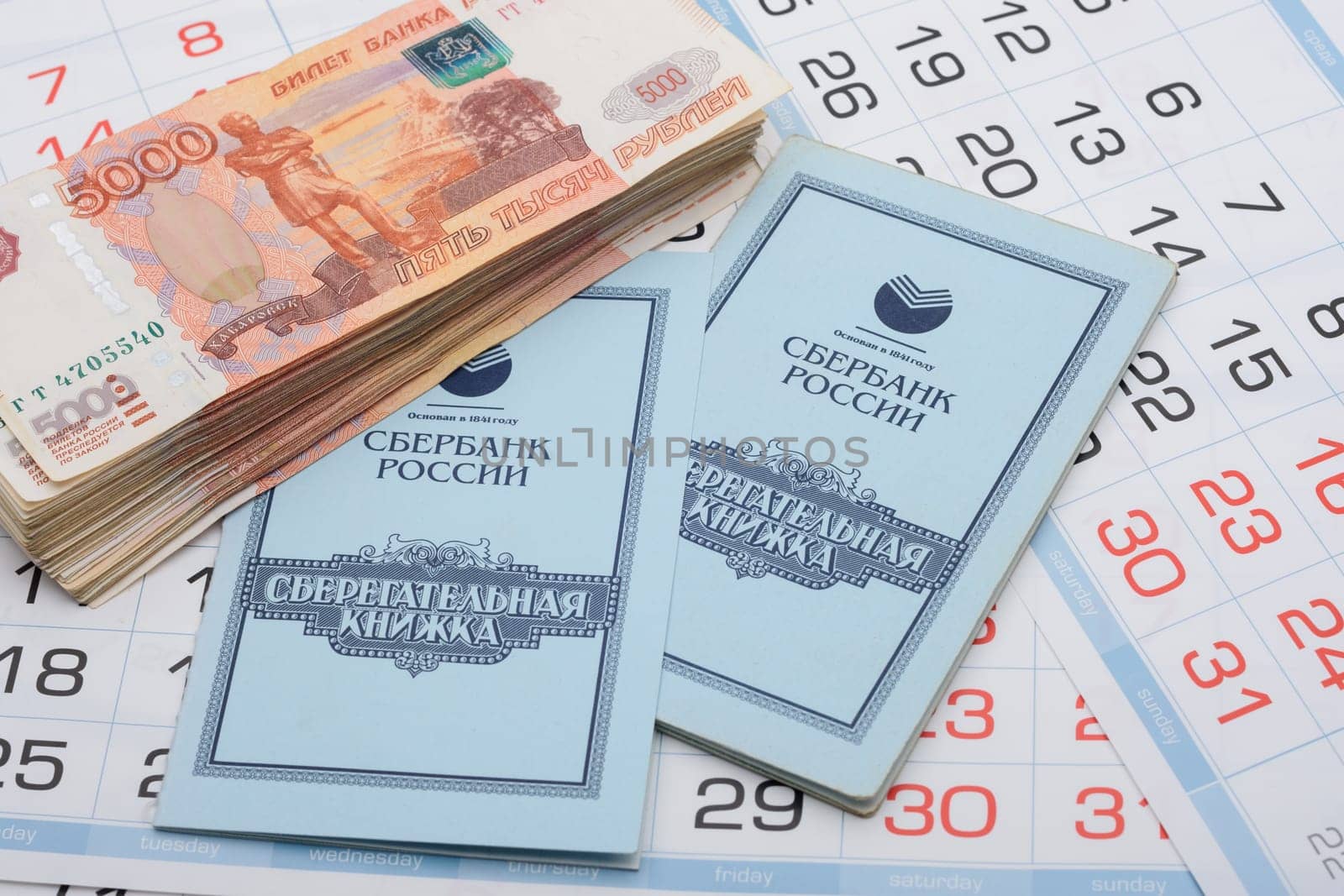 Anapa, Russia - 29.06.2020: The calendar contains a savings book and a large bundle of five thousandth Russian bills