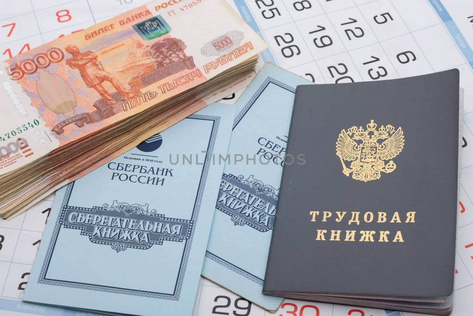 Anapa, Russia - 29.06.2020: The calendar contains a work book, a savings book and a large bundle of five thousandth Russian bills
