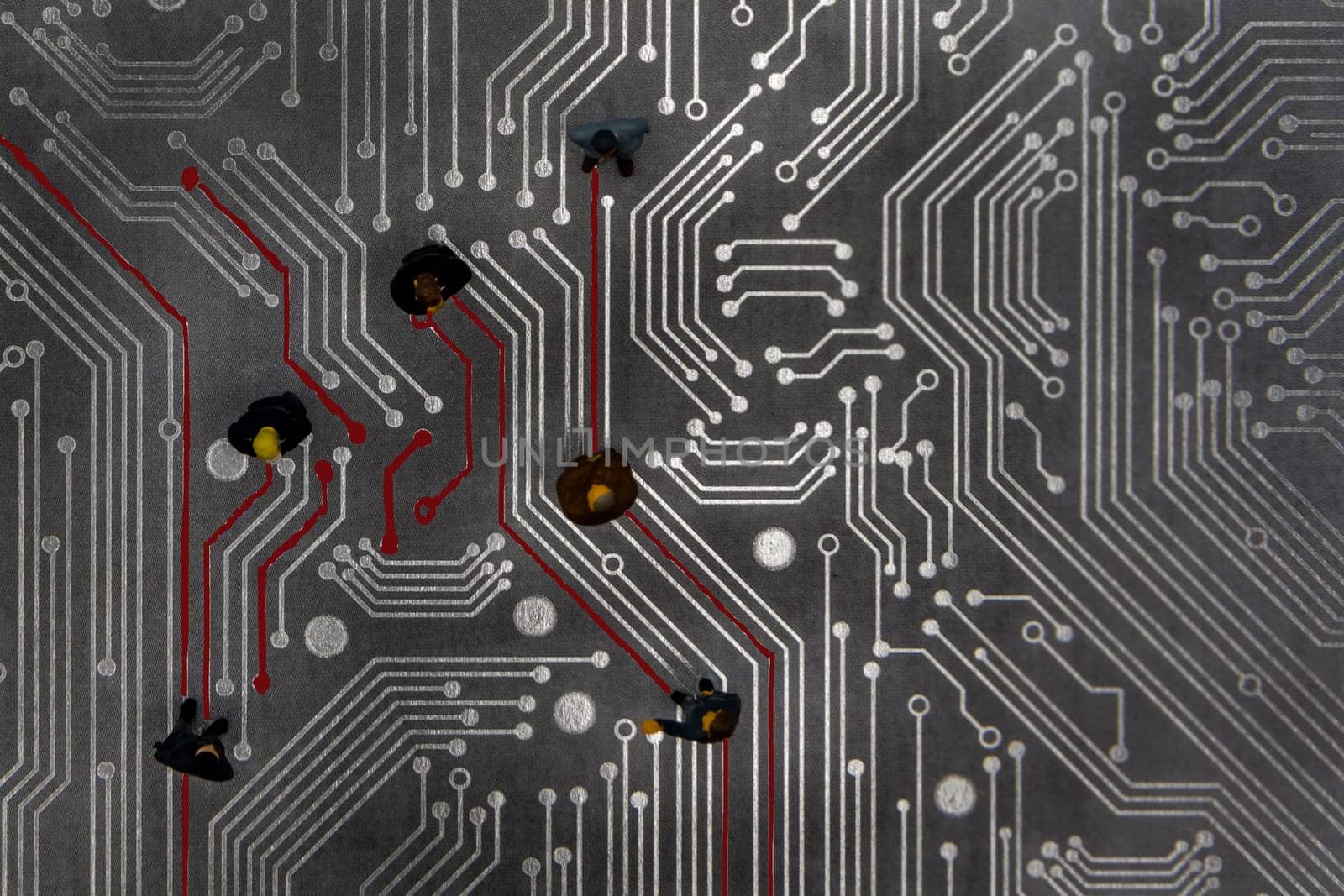 Miniature figurines posed as connected business people in a meeting over abstract futuristic circuit board, future business concept