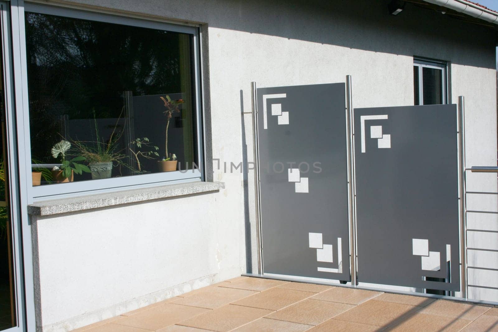 A terrace with stainless steel railings and beige floor tiles.