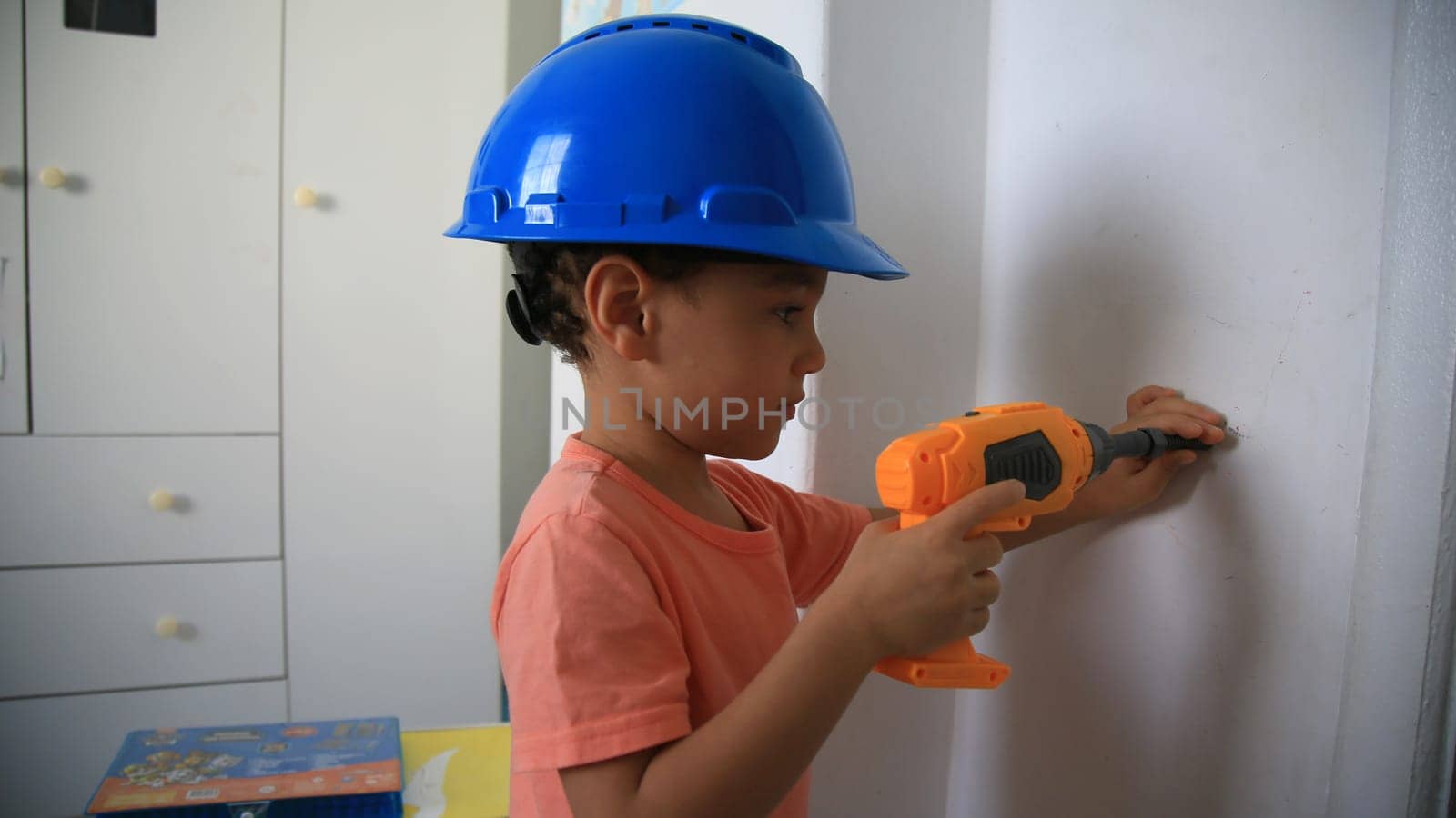 salvador, bahia / brazil - august 4, 2020: child wearing protective helmet plays construction.